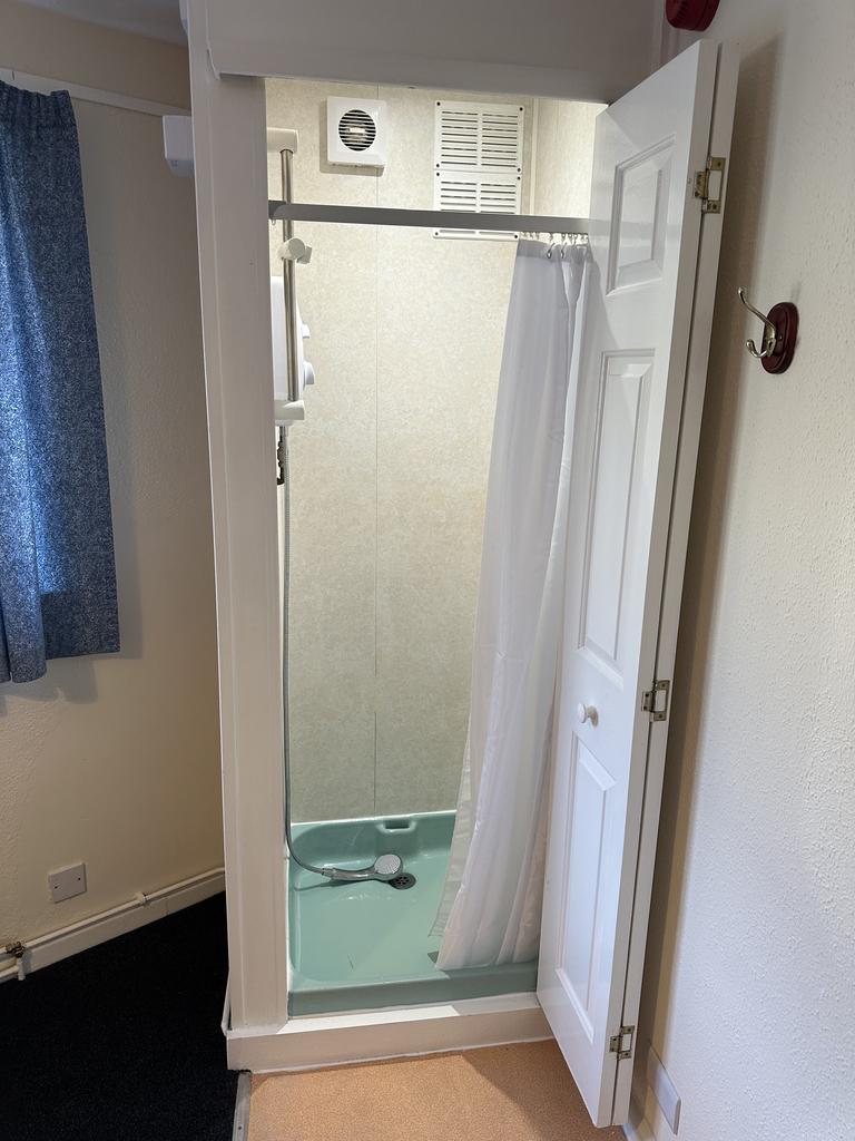 A tidy bathroom featuring a shower and good sto...