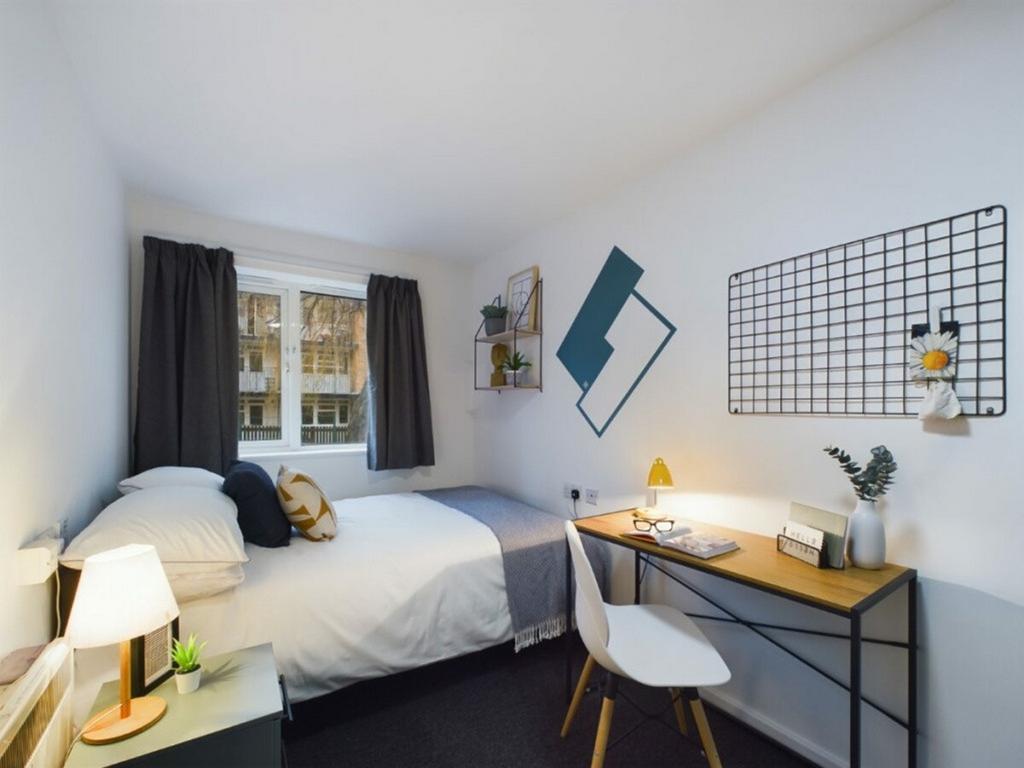 A bright and inviting double bedroom with a coz...