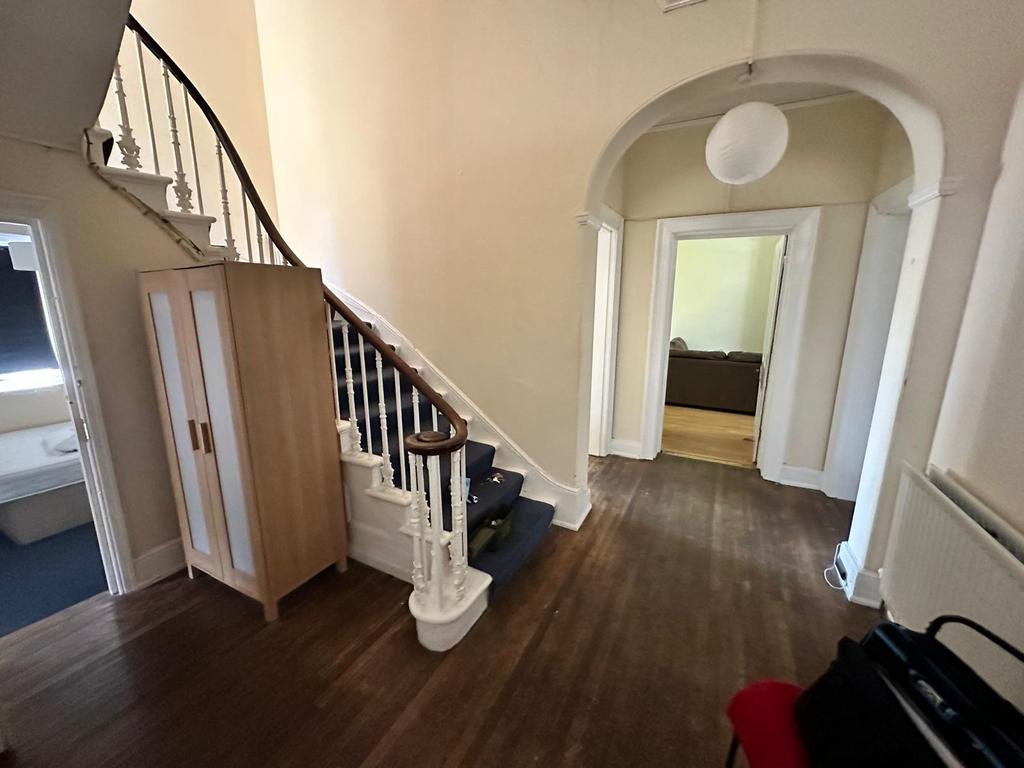Spacious entrance hallway with a curved stairca...