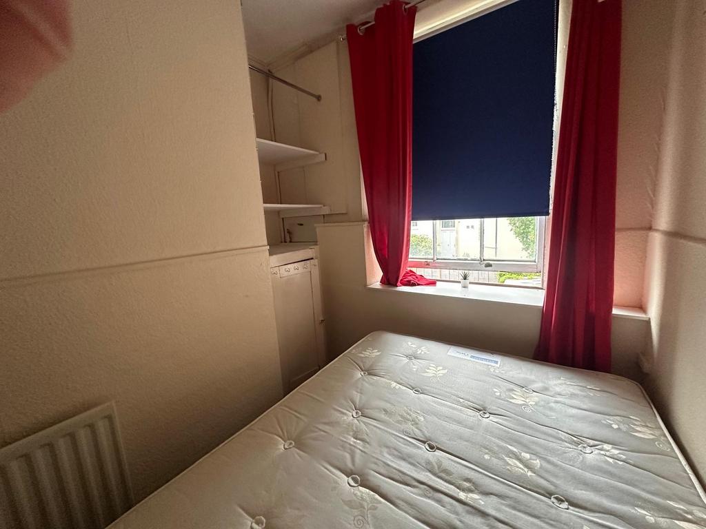 Compact bedroom with a well-presented mattress,...