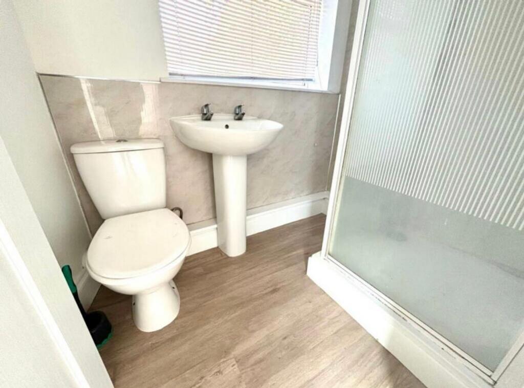 A modern and tidy bathroom featuring a shower a...