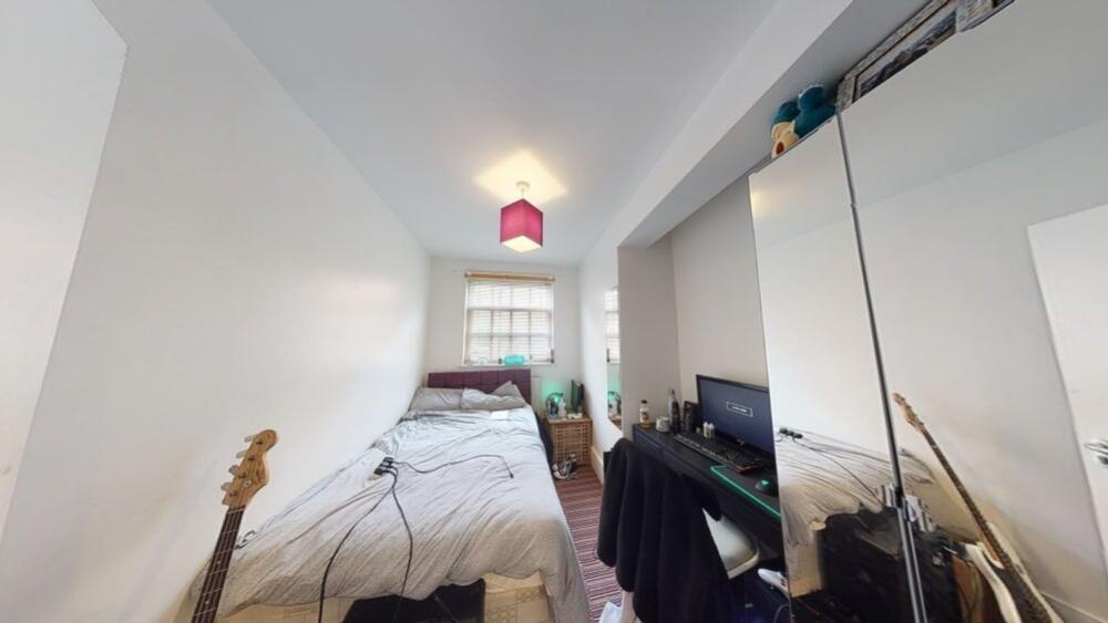 A neat and cozy bedroom with a single bed, brig...