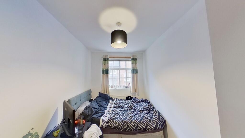 A cozy double bedroom featuring a large window ...