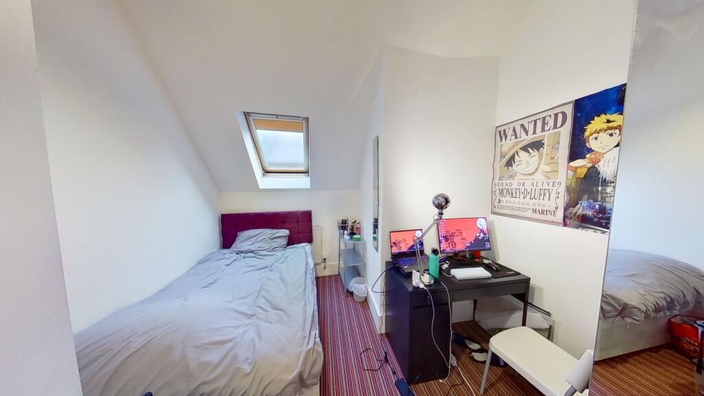 A cozy single bedroom featuring a comfortable b...
