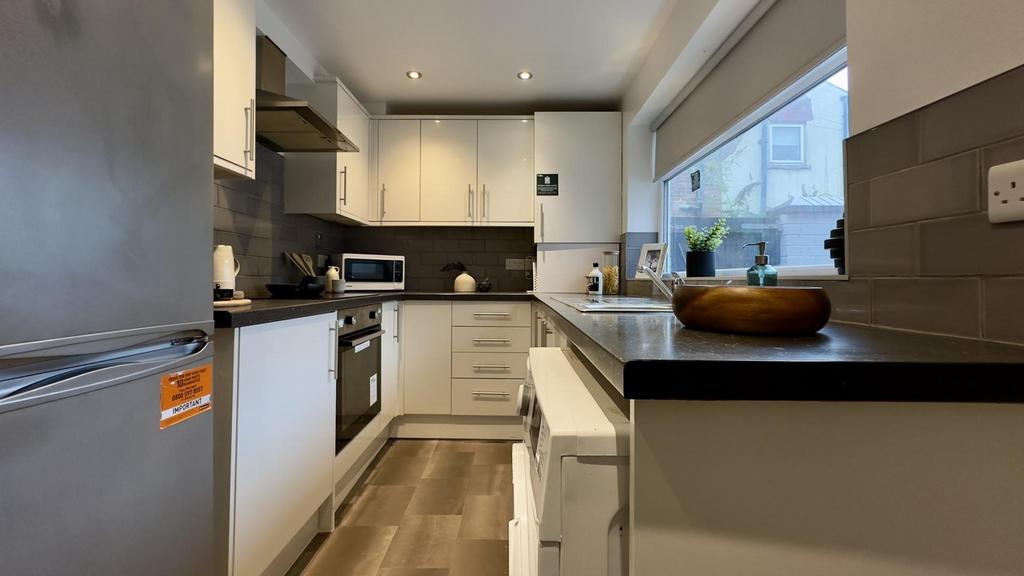A modern and clean kitchenette with ample natur...