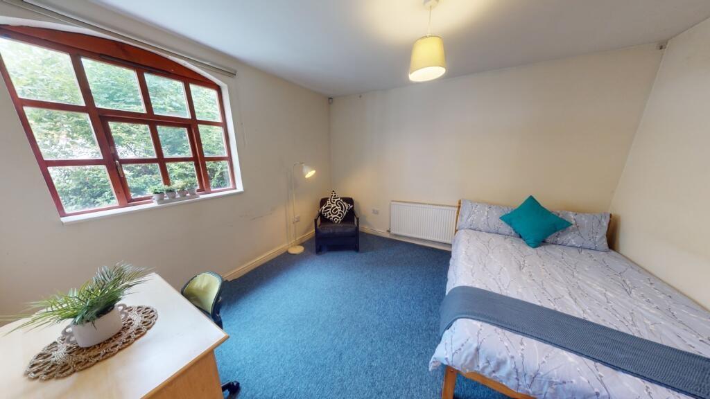 A cozy single bedroom featuring a comfortable s...
