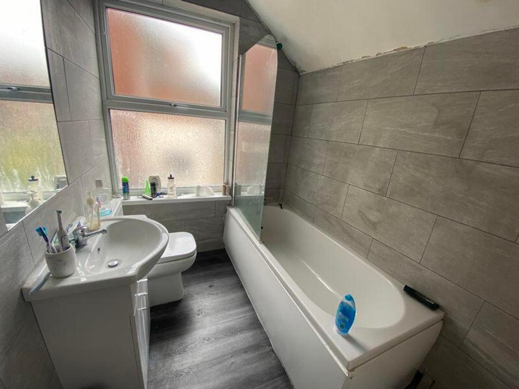 A bright and modern bathroom featuring a bathtu...