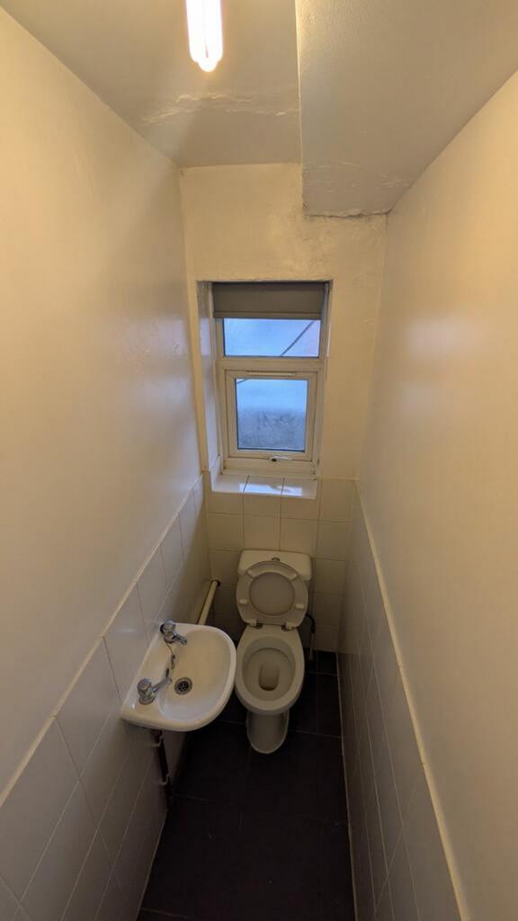 A tidy single toilet with natural light, provid...