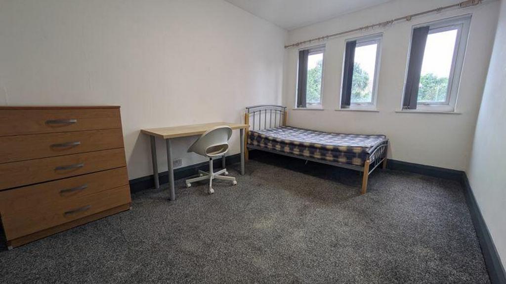 A spacious and tidy double bedroom with ample n...