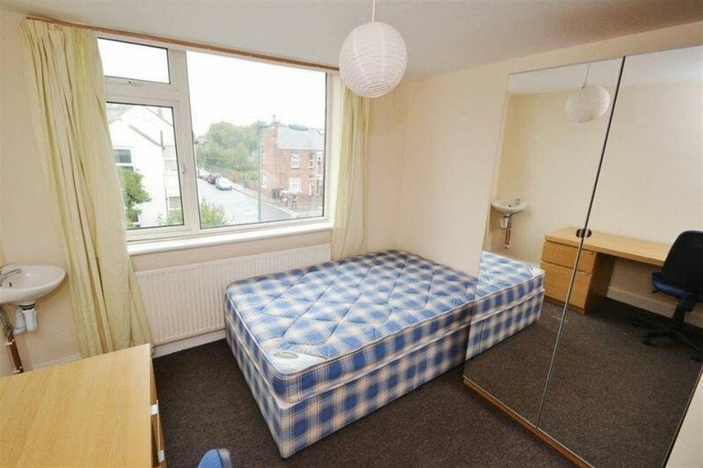 A spacious and well-lit double bedroom with lar...