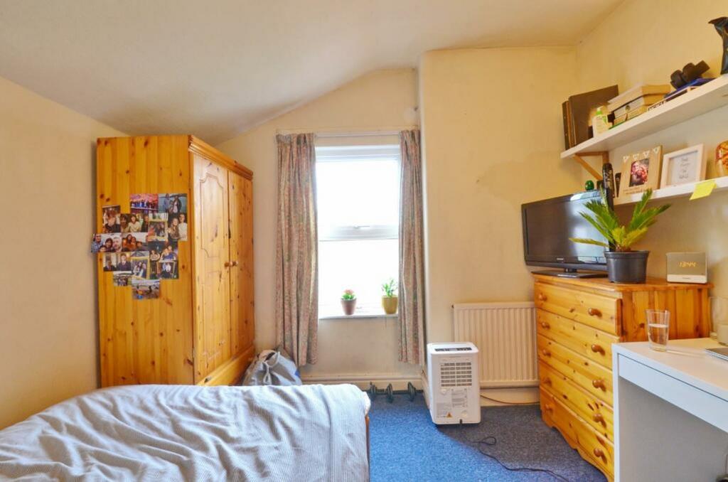 A cozy double bedroom with a warm wooden wardro...