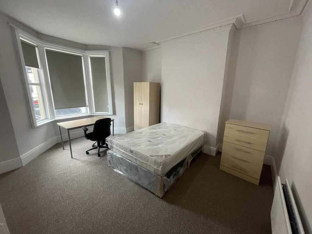 Bright, spacious bedroom with a large bay windo...