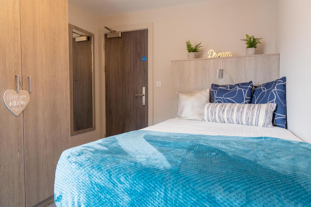 Bright, neatly styled bedroom with a comfortabl...