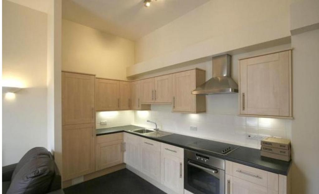 Modern kitchen featuring light wood cabinetry a...