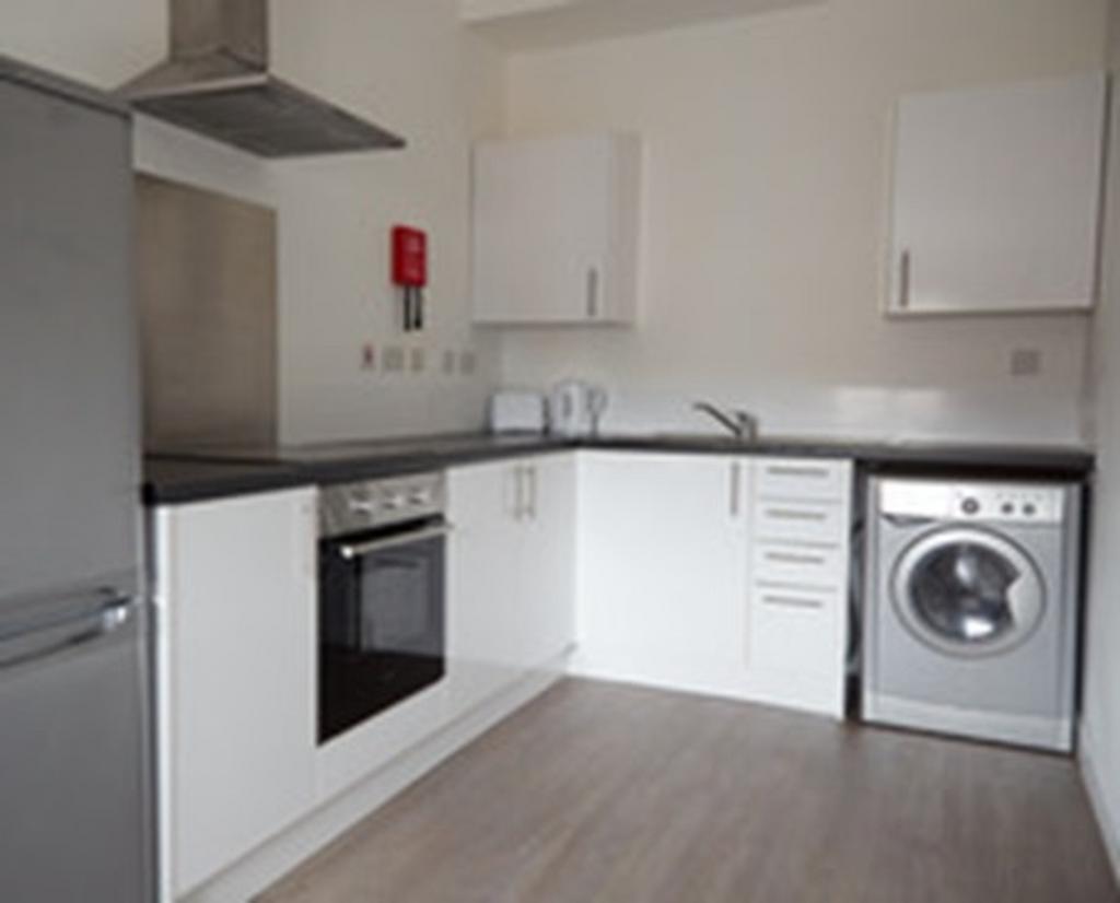 A modern and tidy kitchenette with ample storag...