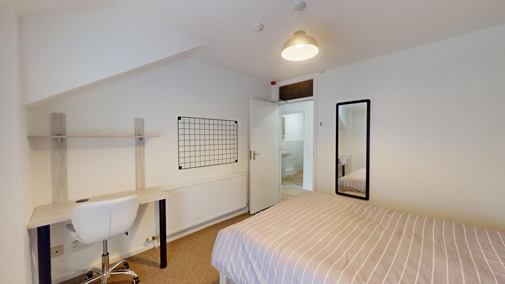 A spacious and well-lit double bedroom with a m...