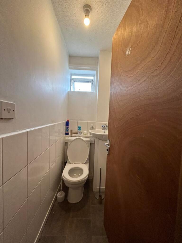 A tidy single toilet with functional amenities,...