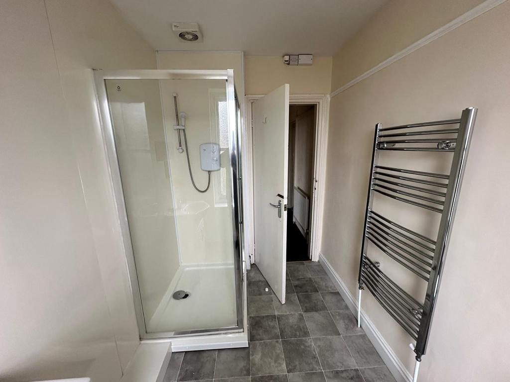 Clean, modern bathroom with a fully enclosed sh...
