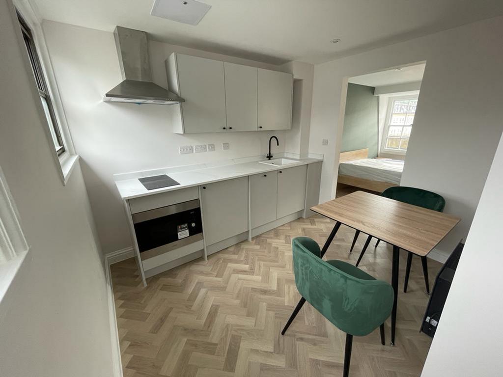 A modern kitchenette featuring sleek cabinetry ...