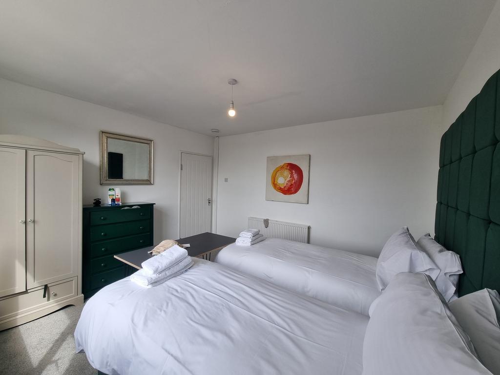 A tidy double bedroom featuring two beds, a war...