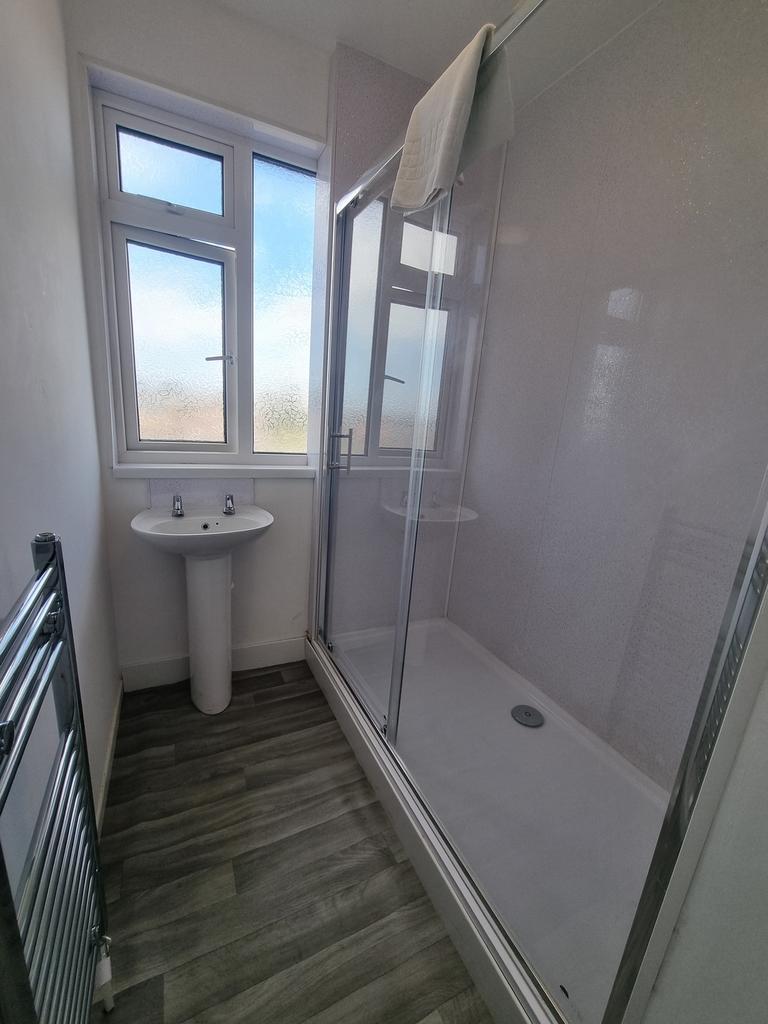 A clean and well-lit bathroom featuring a showe...