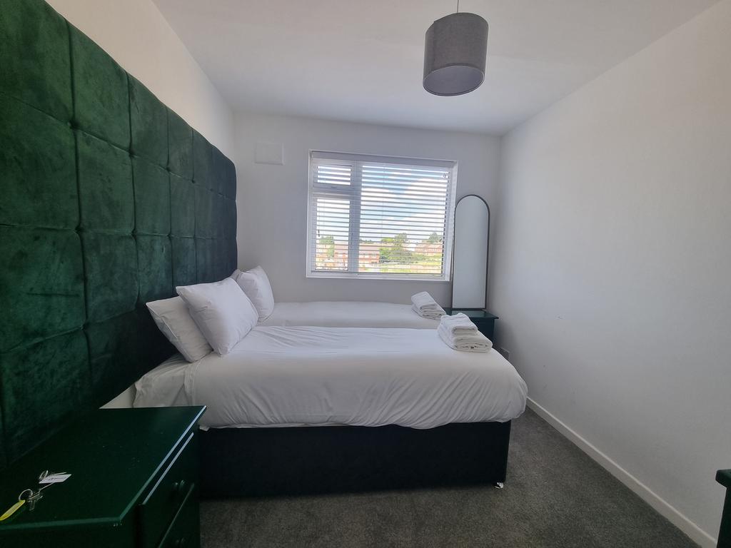 A clean and well-lit double bedroom with two si...