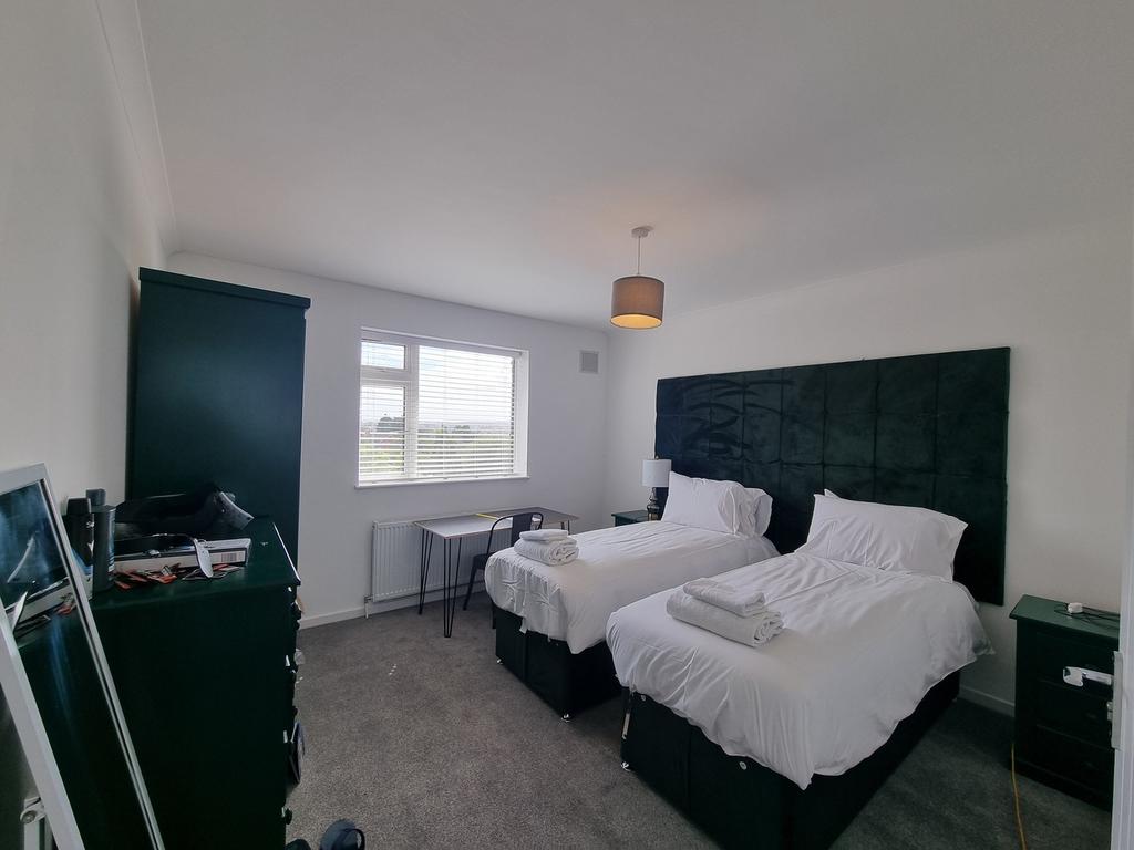 A spacious double bedroom with two beds, good n...