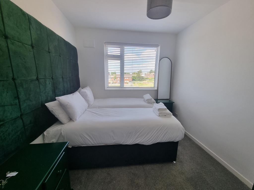A clean and well-lit double bedroom with a gree...