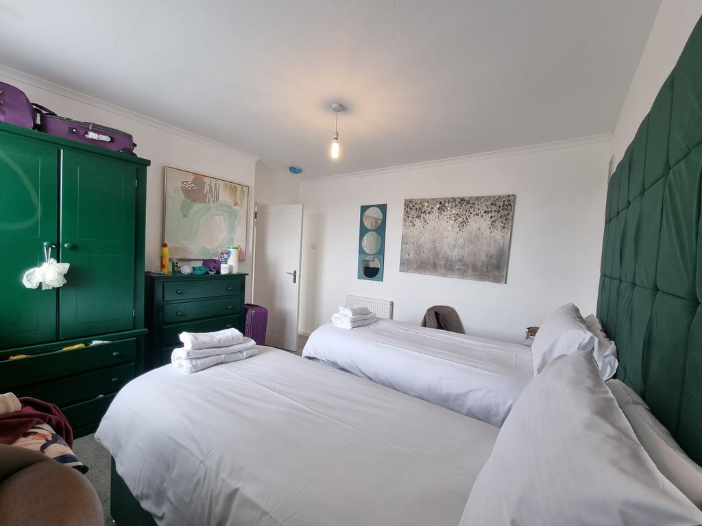 A clean and well-lit double bedroom with two be...