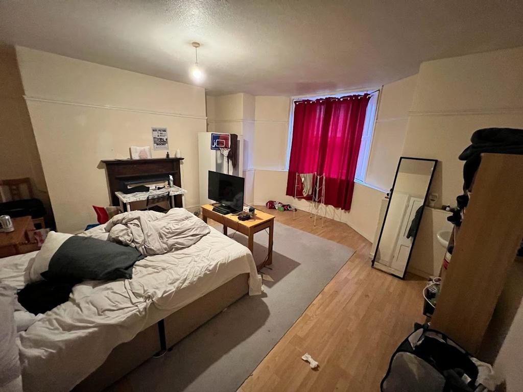 A spacious double bedroom featuring large windo...