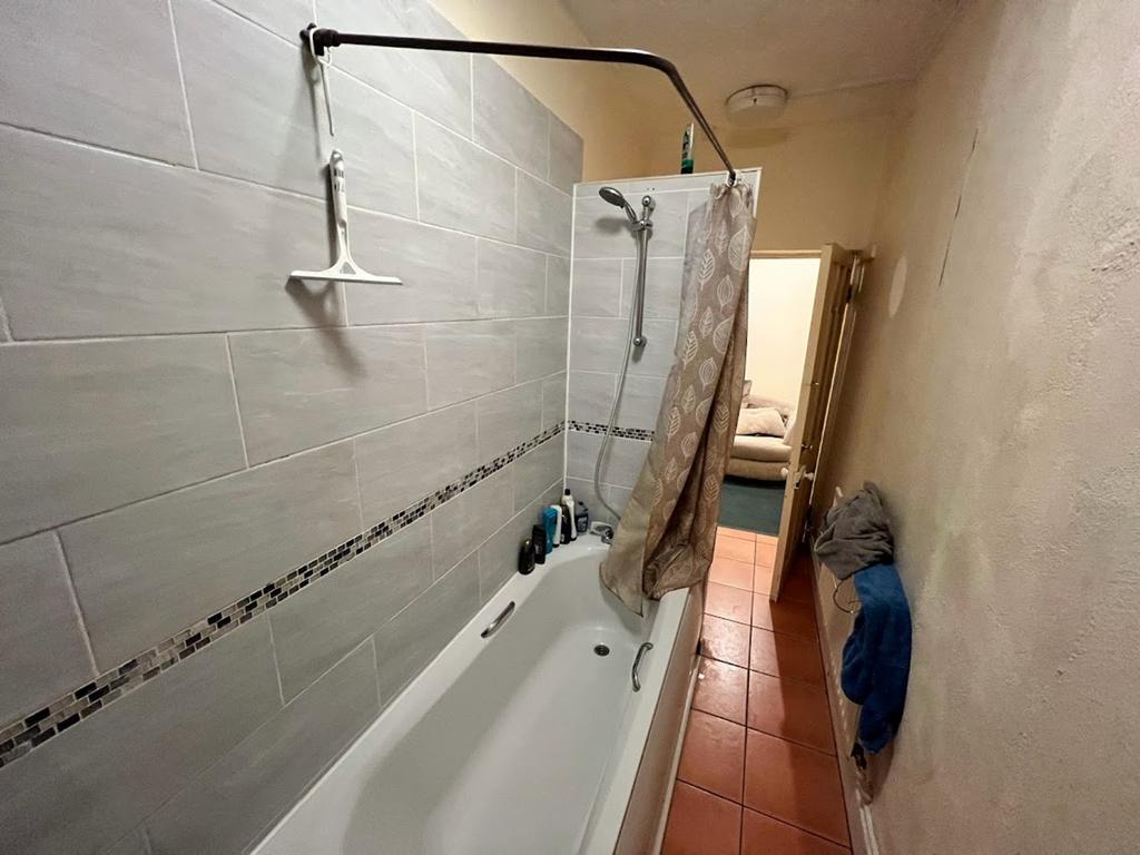 A functional bathroom featuring a bath and show...