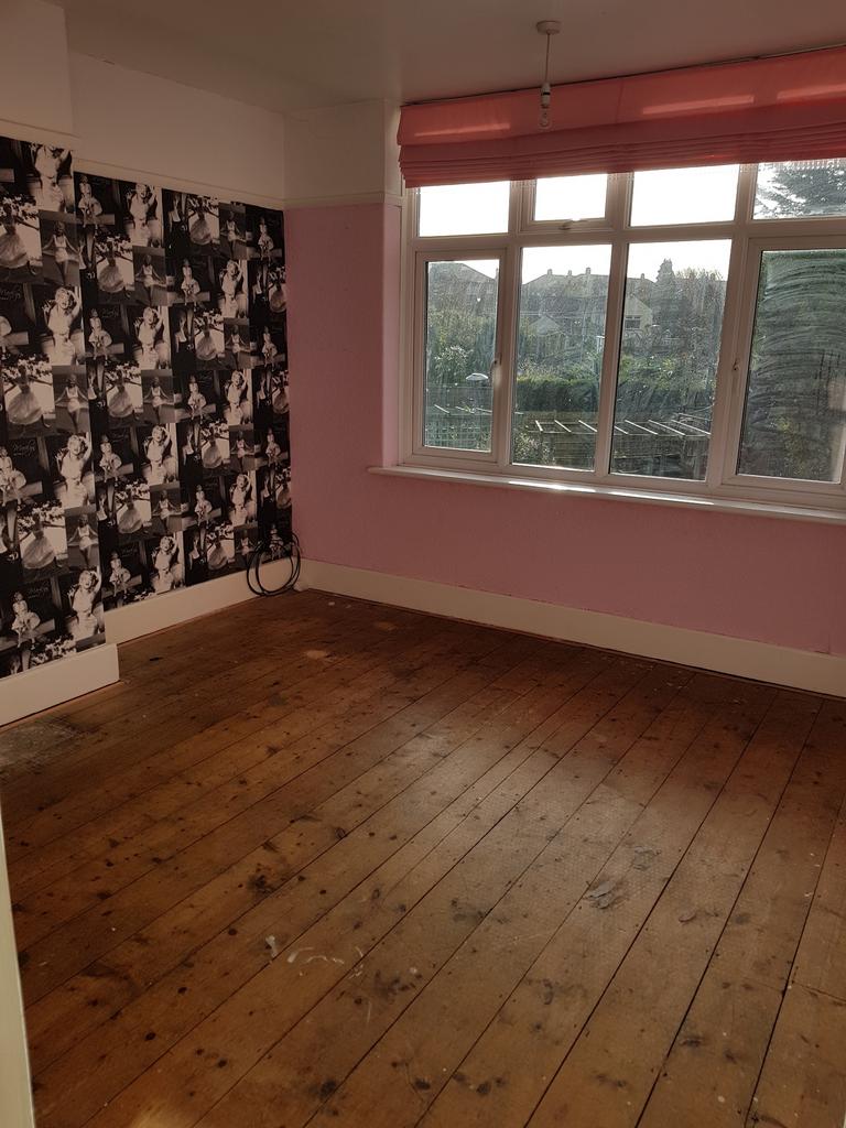 A spacious double bedroom featuring large windo...