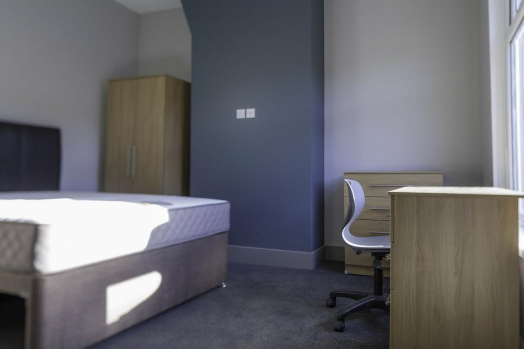 A spacious and well-lit double bedroom, perfect...