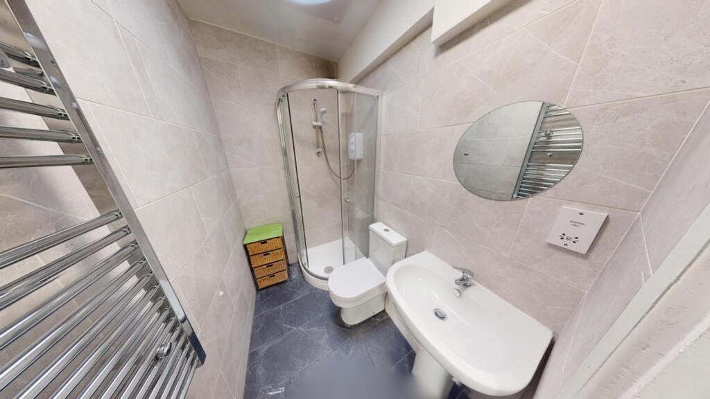 A modern and tidy bathroom featuring a shower a...