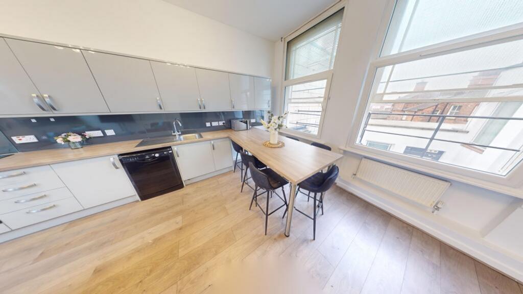 A modern and stylish kitchen with ample natural...