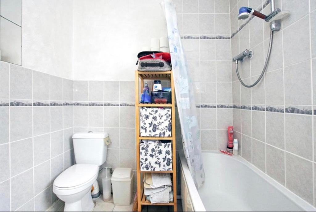 A tidy and bright bathroom featuring a shower a...