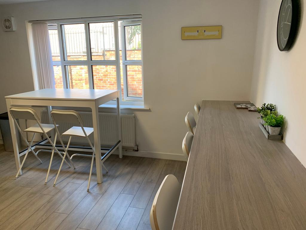 A bright and clean communal workspace with ampl...