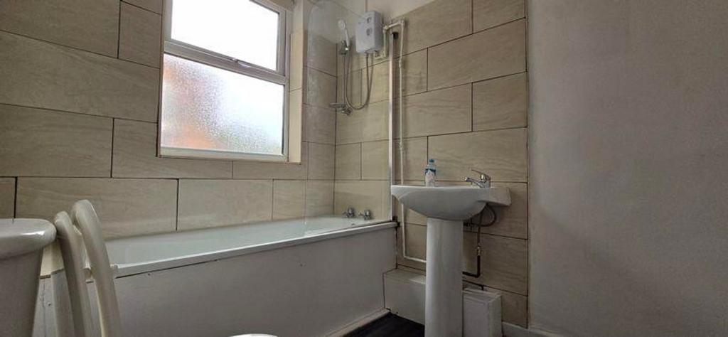 A spacious and bright bathroom featuring a comf...