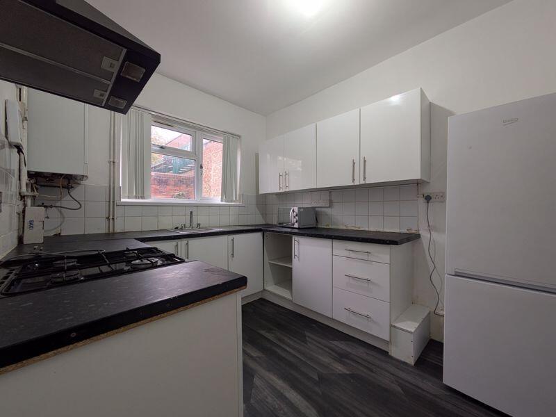 Bright, modern kitchen with plenty of white sto...