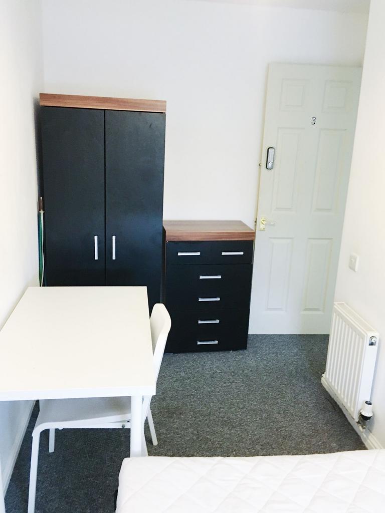 Bright, simply furnished bedroom with a study t...