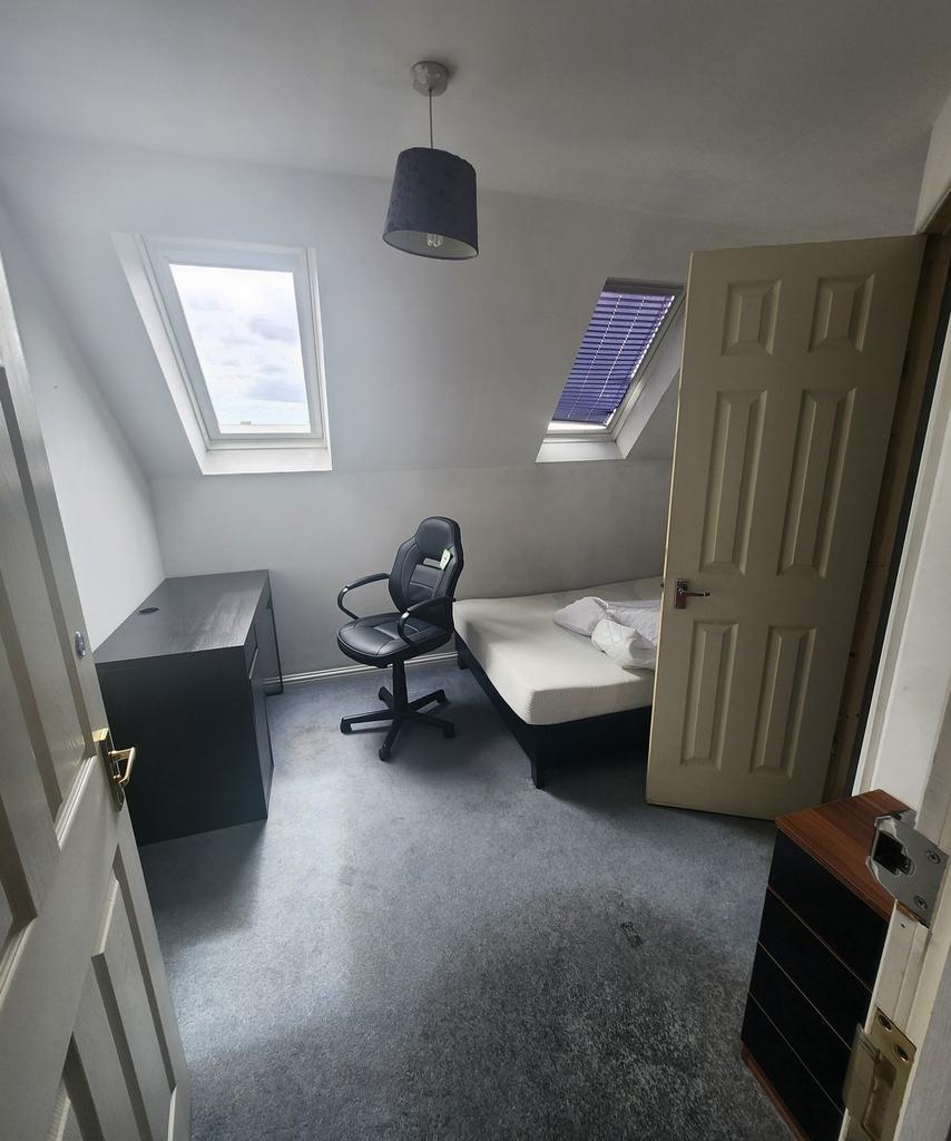 A cozy single bedroom featuring two skylight wi...