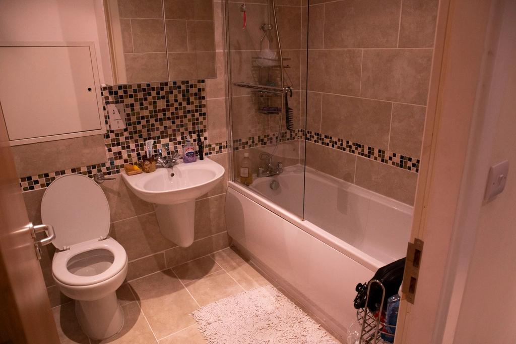 Modern bathroom suite featuring a bath with sho...