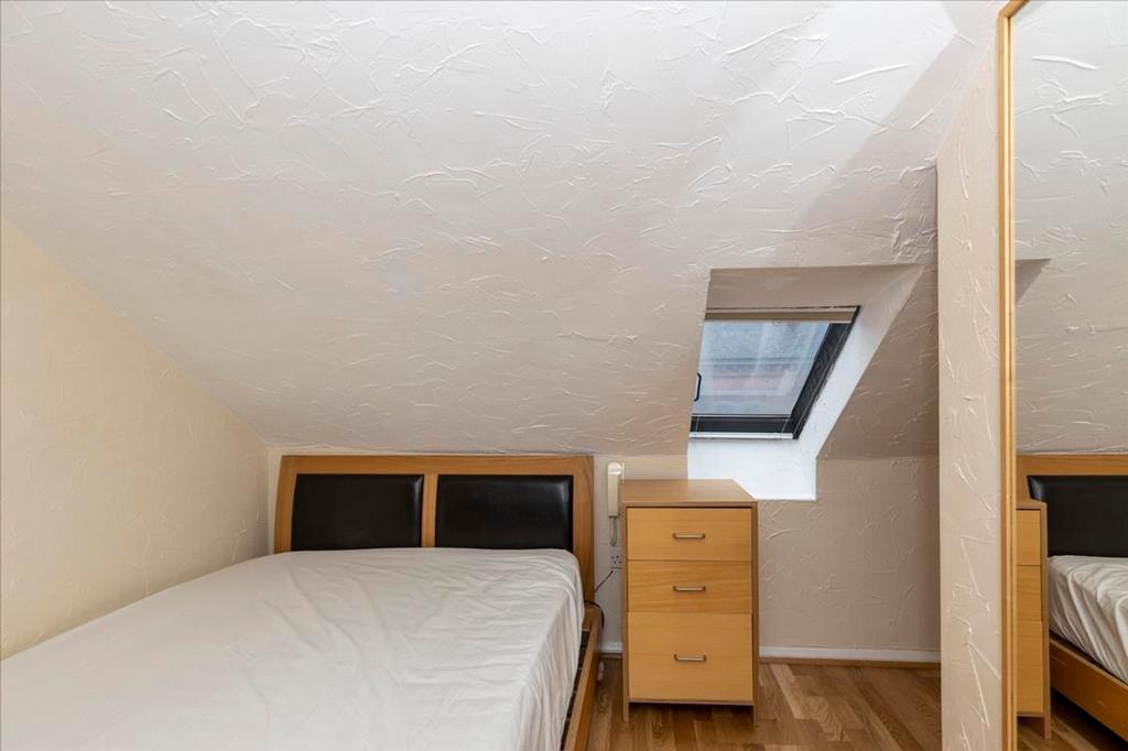 A cozy double bedroom featuring a minimalist de...