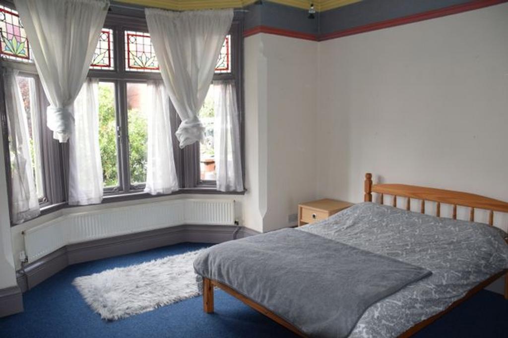A bright and spacious double bedroom featuring ...