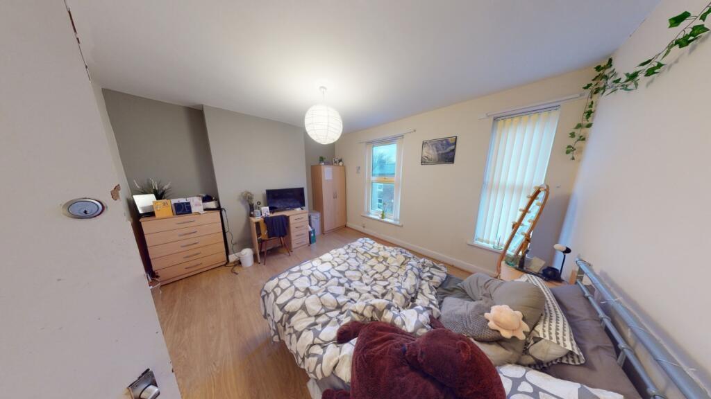 A spacious, well-lit master bedroom featuring a...