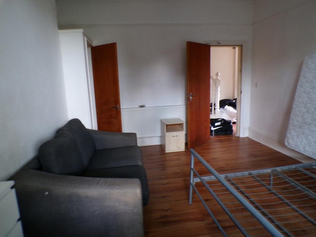A spacious double bedroom featuring a cozy sofa...