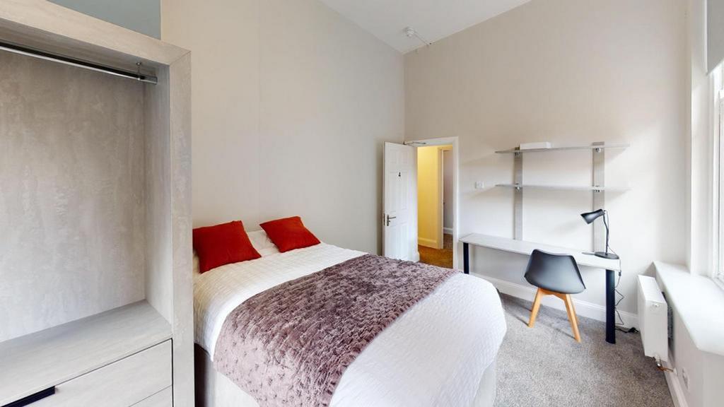 A bright and inviting double bedroom with a com...