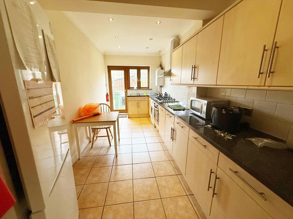Long kitchen with door leading to rear garden