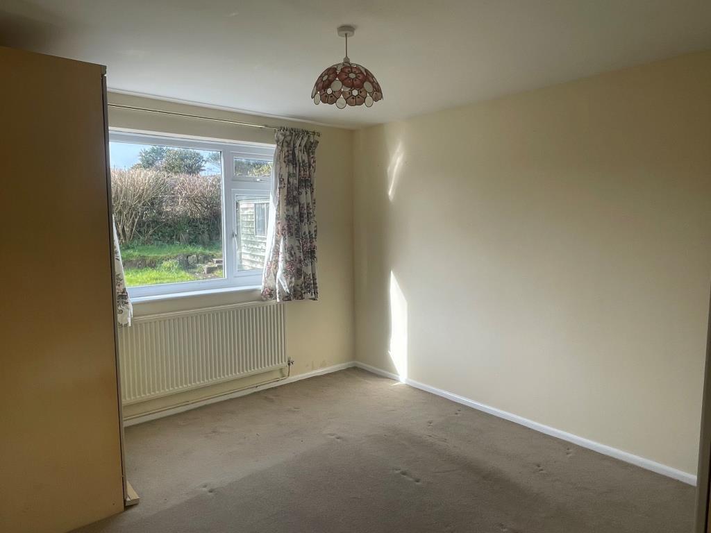 Bedroom with radiator and window looking out to re