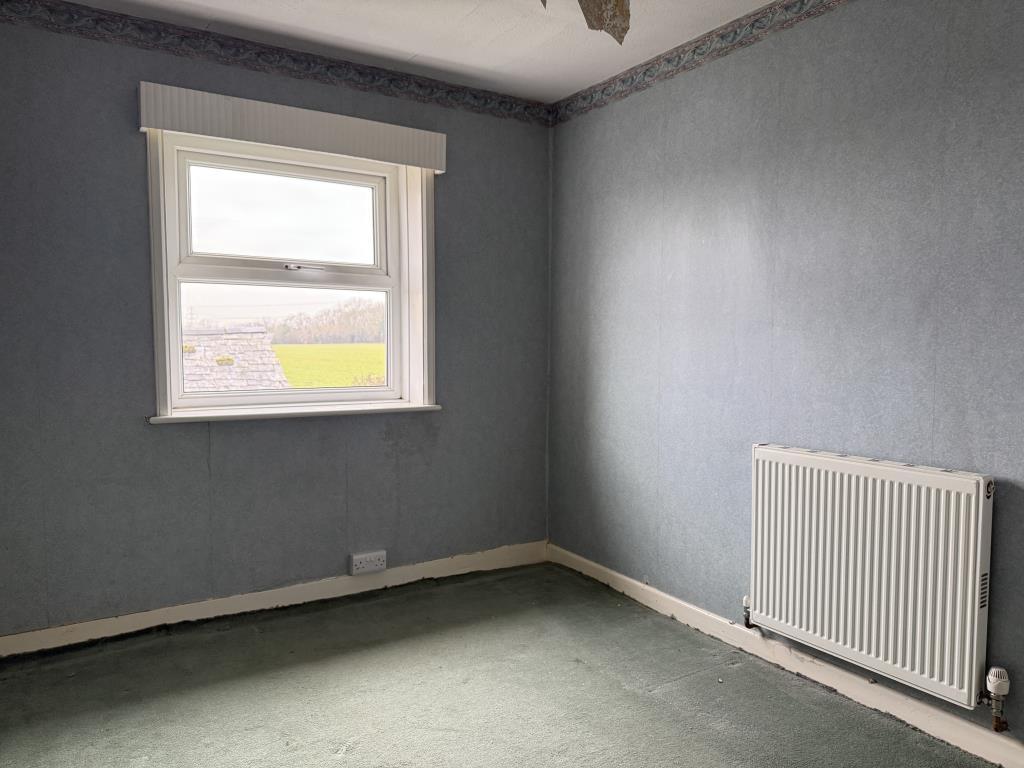 Bedroom with wallpapered walls and carpet